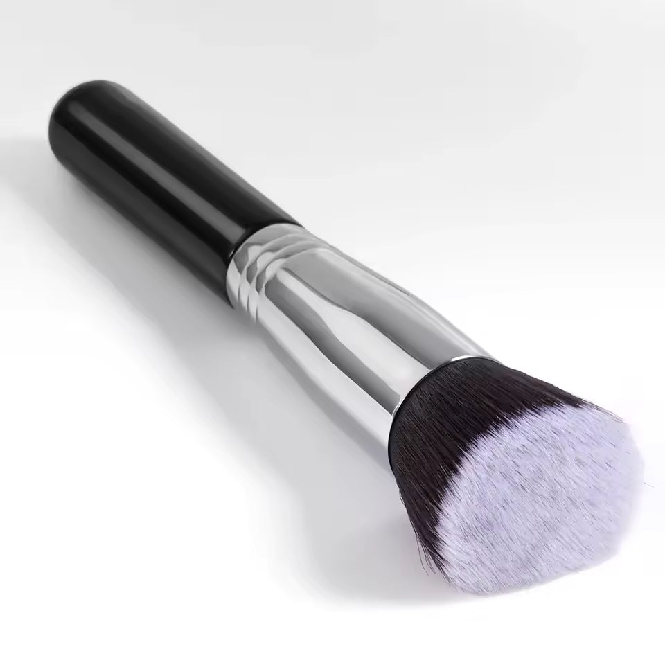 Makeup brush with black handle and white bristles on a light gray background